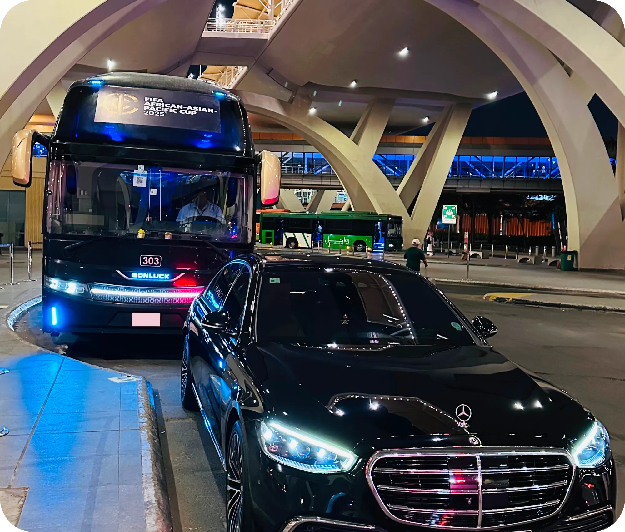 TraffiQ event transportation with a luxury Mercedes sedan and Bonluck coach are parked outside airport terminal in Jeddha